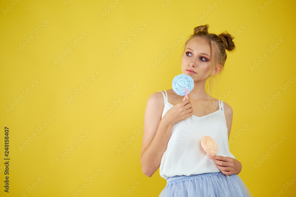 young girl with candy on a yellow bright background. beautiful make-up, young girl with candy on a yellow bright background. beautiful make-up,