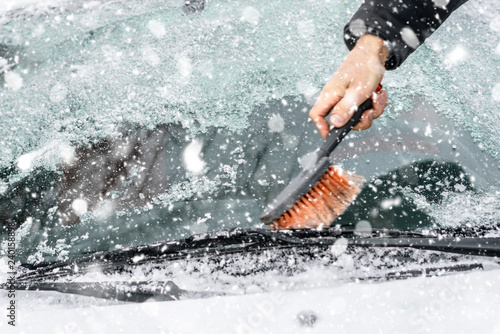 hand cleaning up windscreen from snow and ice in a winter season © Mihail