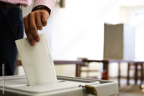 Wahlzettel wird in Urne geworfen photo