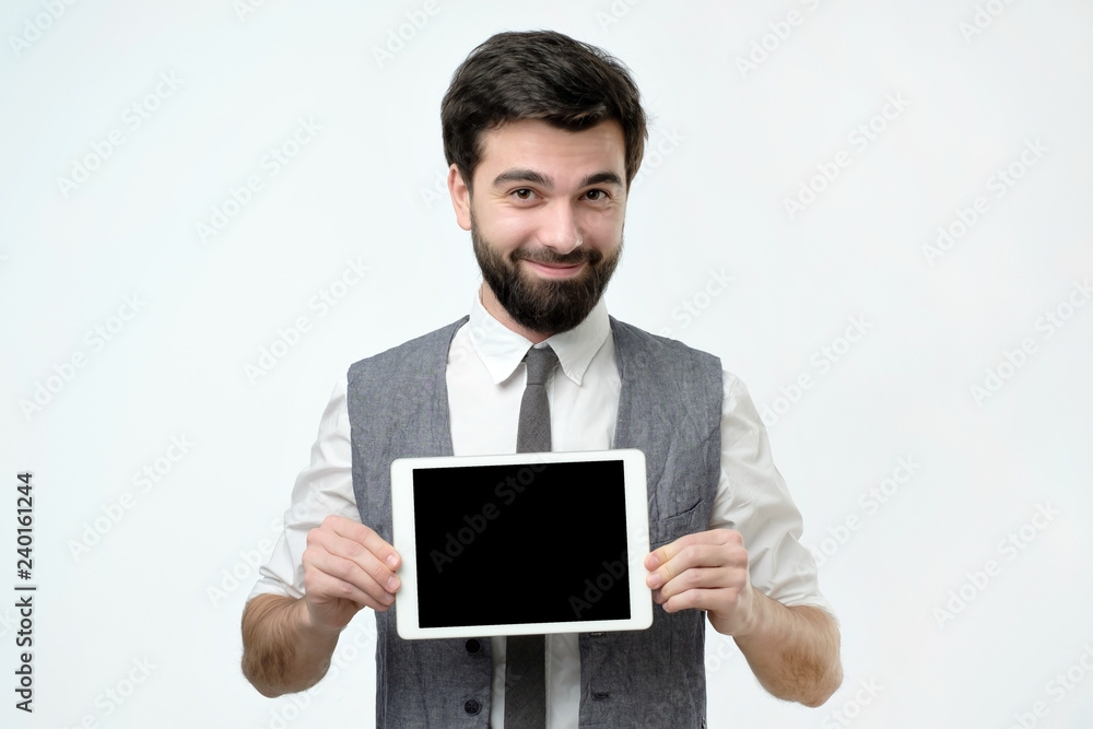 Hispanic man with black beard shows tablet computer with blank screen on white background Hispanic man with black beard shows tablet computer with blank screen on white background