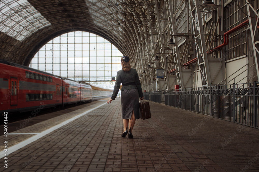 girl with a suitcase in hand and in retro clothes walking down the station girl with a suitcase in hand and in retro clothes walking down the station