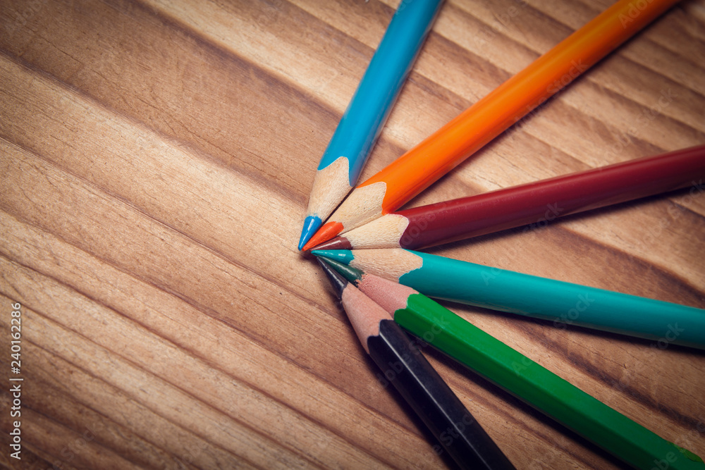 Fototapeta premium Multicolored pencils for creative work on a wooden background.