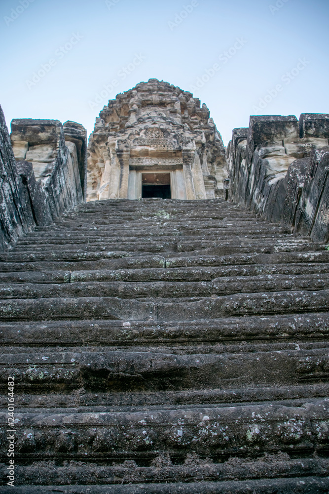 Fototapeta premium iew up the steep stairs at Angkor wat. Originally constructed in the early 12th century, the ruins are a huge tourist attraction as well as a place of worship today