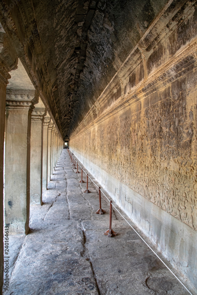 View along a corridor at Angkor wat. Originally constructed in the early 12th century, the ruins are a huge tourist attraction as well as a place of worship today