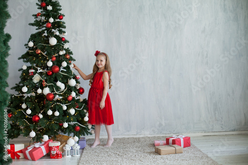 little girl opens Christmas presents new year tree