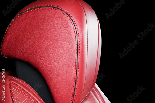 Red leather interior of the luxury modern car. Perforated red leather comfortable seats with stitching isolated on black background. Modern car interior details. Car detailing. Car inside © Aleksei