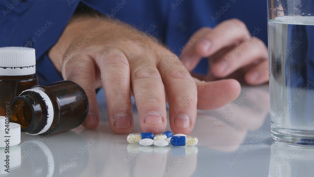 Man Hand Taking Pills from the Table for a Medical Treatment Man Hand Taking Pills from the Table for a Medical Treatment
