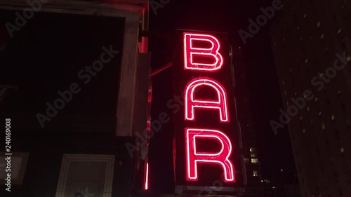 New York City Nighttime NX Establishing Shot CV of Bar Pub. Night exterior video footage of vintage neon sign. New York people go out at night to have fun, drink alcohol, go out on date, get together