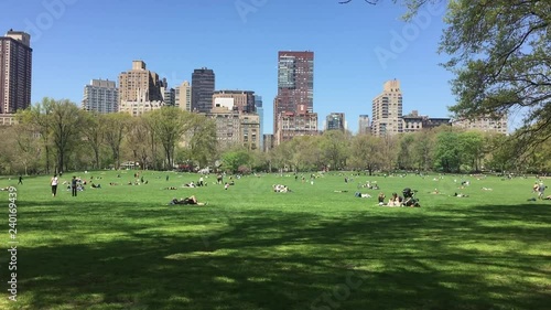 Spring in Manhattan. People in New York City lay out, relax and enjoy the sun and sunbathe and exercise in Central Park Meadow.