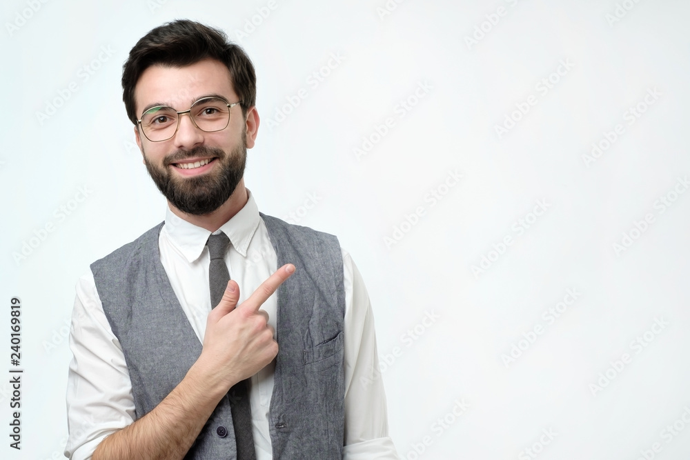 Look over there concept. Happy young handsome man in vest pointing away and smiling. Studio shoot. Look over there concept. Happy young handsome man in vest pointing away and smiling. Studio shoot.
