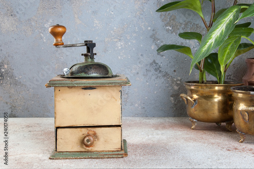 Old coffee grinder on concrete background.