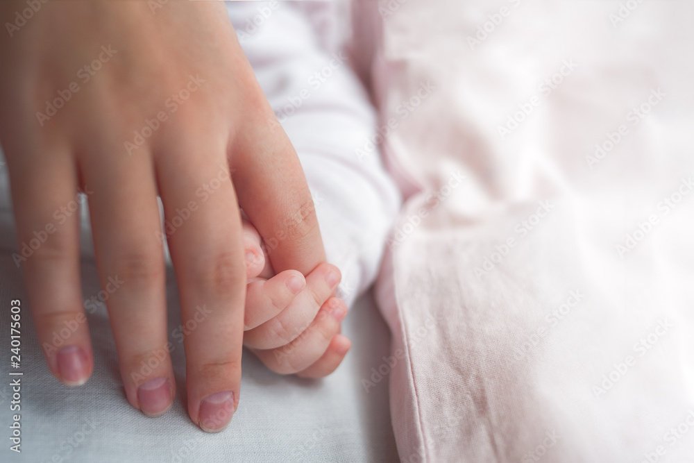 Hand The Sleeping Caucasian Baby In The Hand Of Mother Close Up. New Family And Baby Protection From Mom Concept. Hand The Sleeping Caucasian Baby In The Hand Of Mother Close Up. New Family And Baby Protection From Mom Concept.