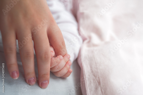 Hand The Sleeping Caucasian Baby In The Hand Of Mother Close Up. New Family And Baby Protection From Mom Concept.