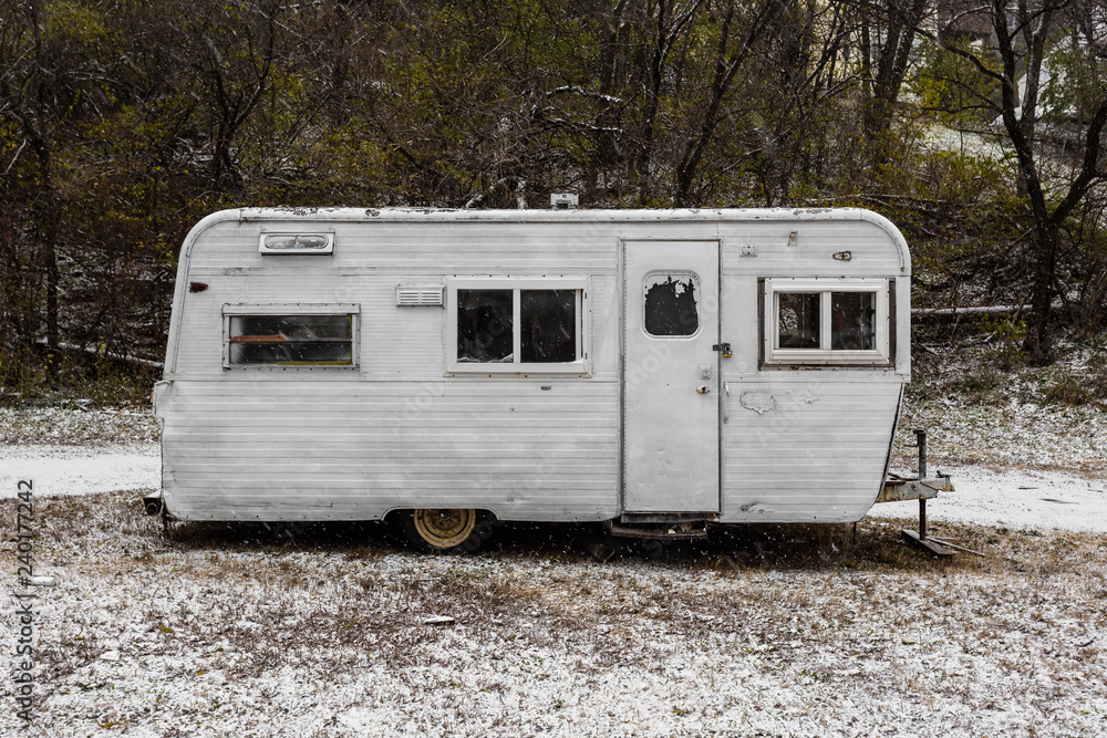 Side view of a vintage classic mobile home trailer sitting on snowy ground  Photos | Adobe Stock