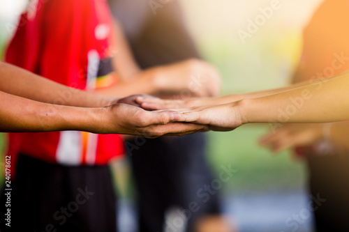 Young boy soccer players tap hands together for football training © Koonsiri