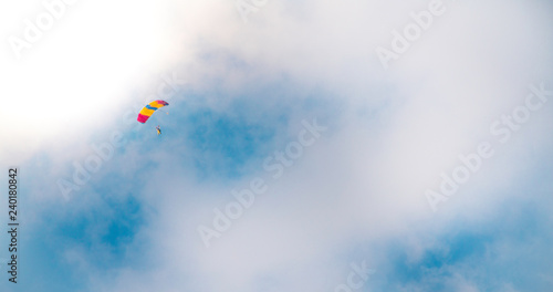 Parachutist in clouded sky