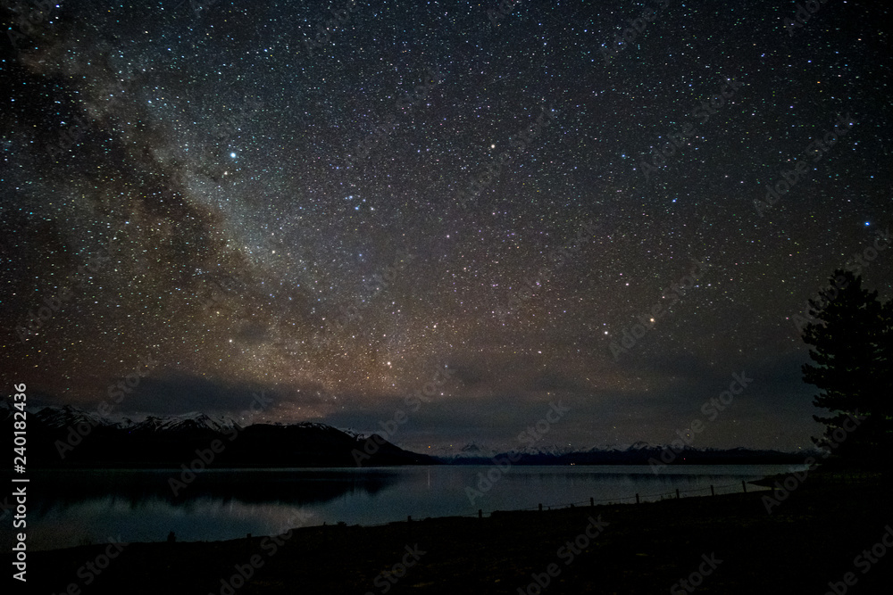 Fototapeta premium Beautiful milky way, starry night over the snow mountain at Lake Pukaki, New Zealand. High ISO Photography.