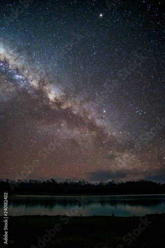 Beautiful milky way, starry night over the snow mountain at Lake Pukaki, New Zealand.