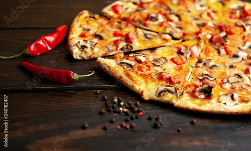 delicious fresh italian pizza on a wooden background straight from the oven.