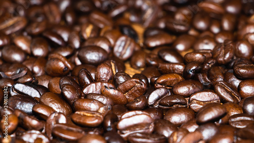 Fresh roasted dark coffee beans. Close up view of oily aromatic coffee.