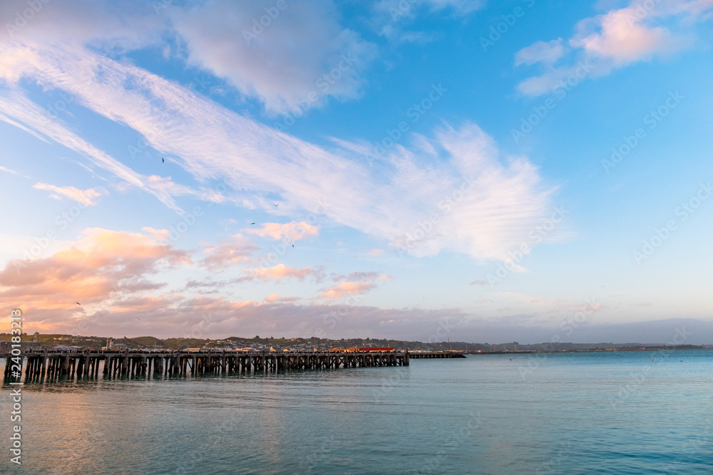 Beautiful sunset at the dock. Blue sky and Ocean with town view. Omaru, New Zealand.