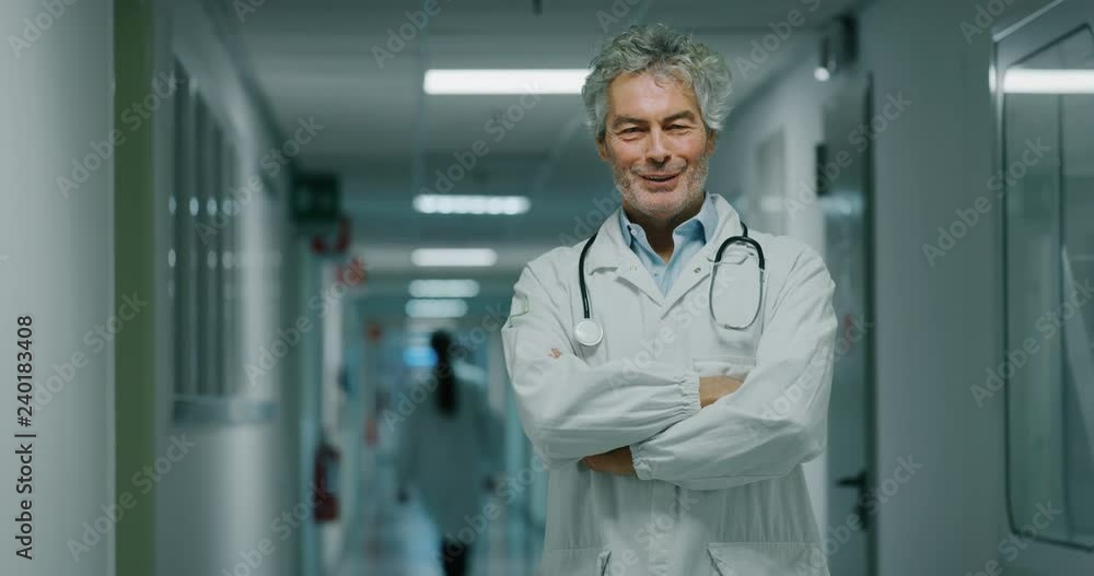 Portrait of smiling male doctor satisfied with his job in a corridor of a hospital. Concept of medicine, technology, health care and people, hospital Portrait of smiling male doctor satisfied with his job in a corridor of a hospital. Concept of medicine, technology, health care and people, hospital