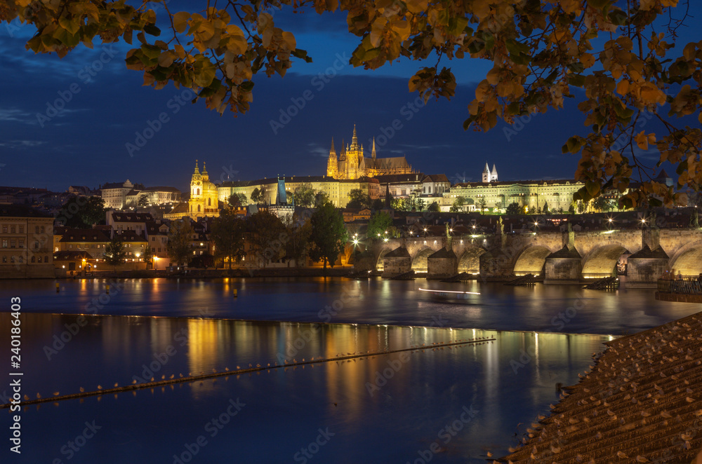 Prague - The Charles Bridge, Castle and Cathedral from promenade over the  Vltava river at dusk.