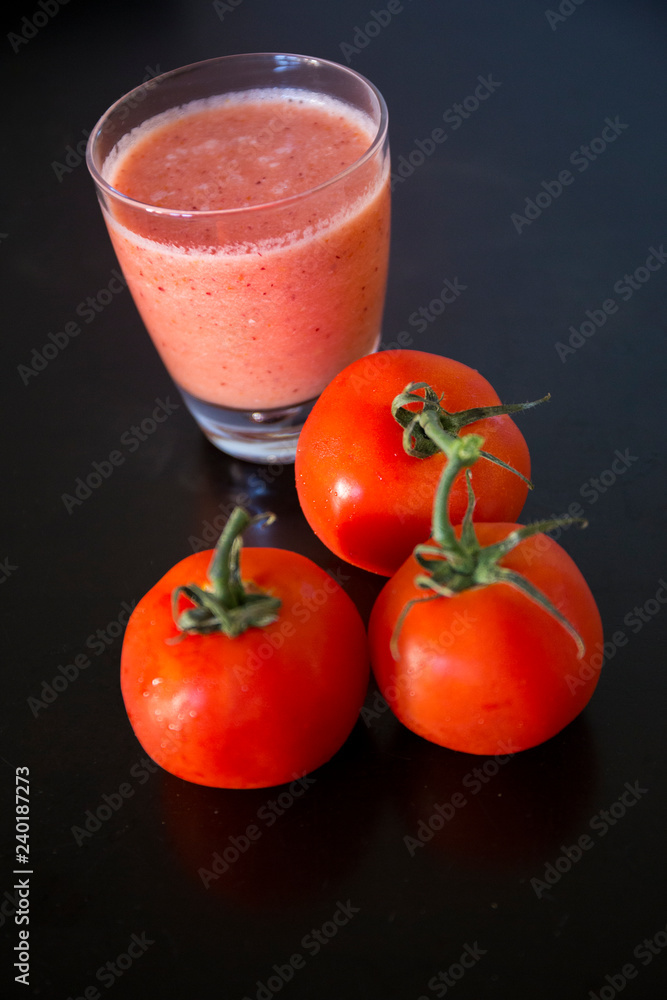 A glass of tomato juice with fresh tomatoes A glass of tomato juice with fresh tomatoes