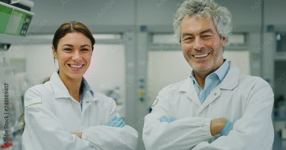 Portrait of two smiling scientists satisfied with a great results of completed research in laboratory. Shot in 8K. Concept: research,biochemistry, pharmaceutical medicine,teamwork Portrait of two smiling scientists satisfied with a great results of completed research in laboratory. Shot in 8K. Concept: research,biochemistry, pharmaceutical medicine,teamwork