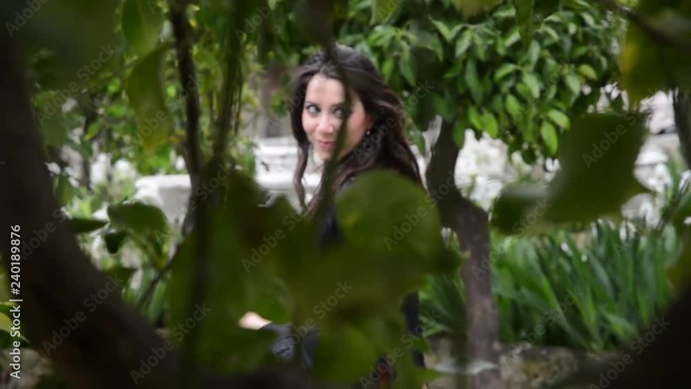 Giovane donna cammina in un giardino Giovane donna cammina in un giardino