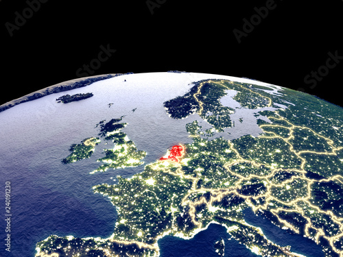 Netherlands from space on planet Earth at night with bright city lights. Detailed plastic planet surface with real mountains.