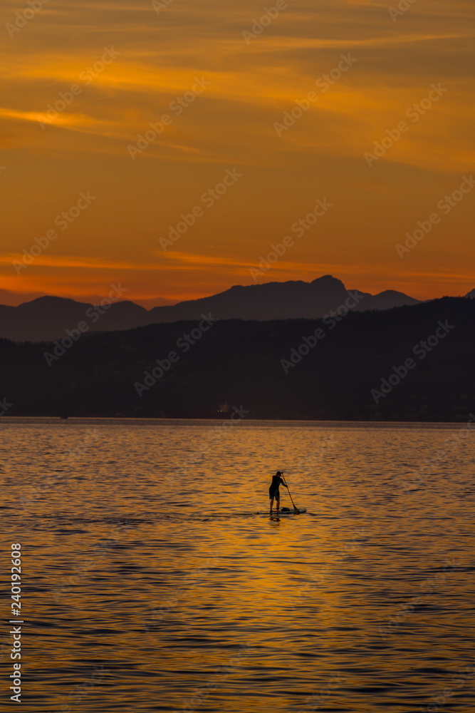 woman on paddlebard at sunset