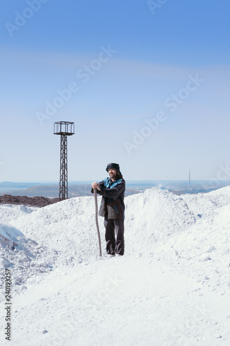 Man In Ethnic Clothes Among The White Mounds Against The Mining Landscape