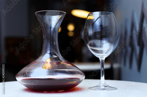Decanter with red wine and glass on a table