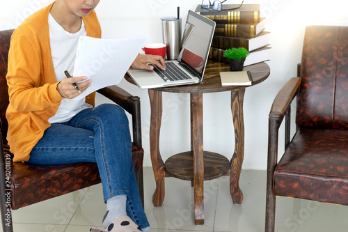 woman work at home with her computer and paper