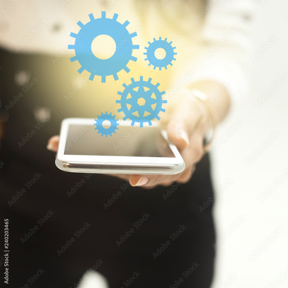 Hands using mobile phone with gear or cogwheel system. Teamwork concept. Hands using mobile phone with gear or cogwheel system. Teamwork concept.