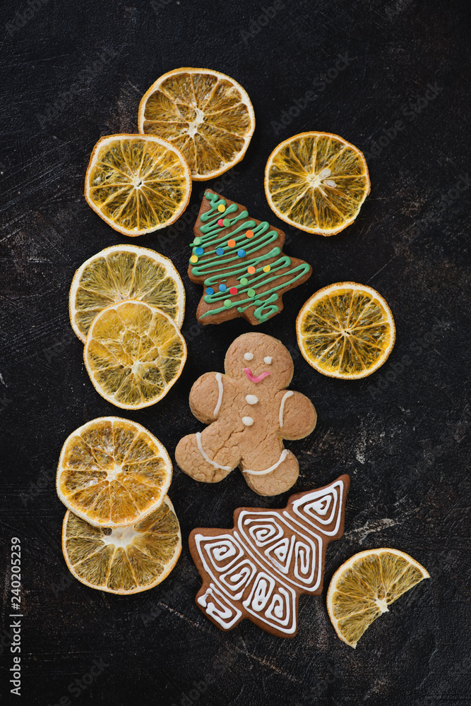 Crispy fruit chips made of orange and gingerbread cookies over dark brown stone surface, above view Crispy fruit chips made of orange and gingerbread cookies over dark brown stone surface, above view