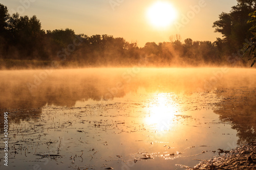 View of river in the mist at sunrise. Fog over river at morning