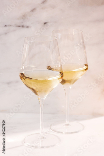 two white wine glasses on marble