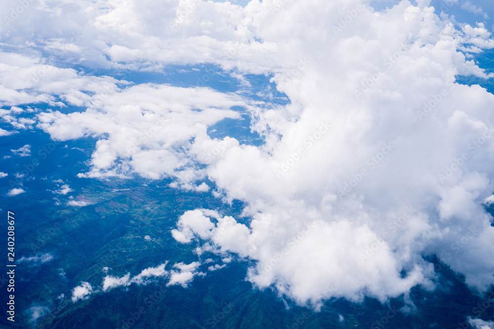 Sky scape cloudscape from aerial airplane shot of blue clouds. View flying above moutain from windows over Loei, Thailand.
