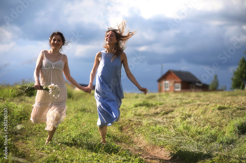 Young girls are walking in the field © alexkich