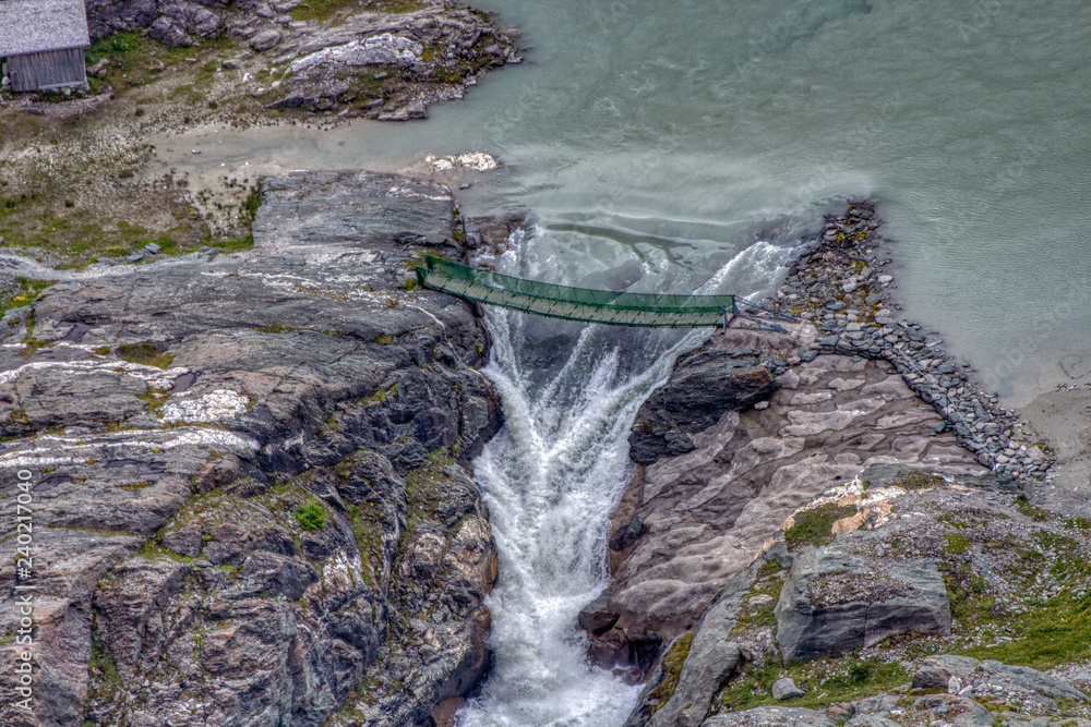 Hängebrücke über Schlucht mit Wasser und Wasserfall,