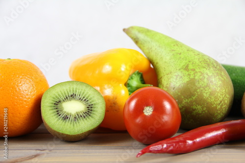 Zdrowa żywność - owoce i warzywa na drwenianej podstawie i jasnym tle