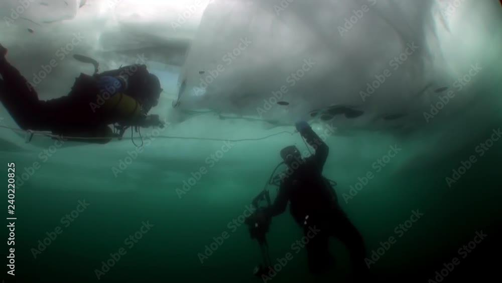Diver with underwater cameraman under ice in cold water of lake Baikal. Diver with underwater cameraman under ice in cold water of lake Baikal.
