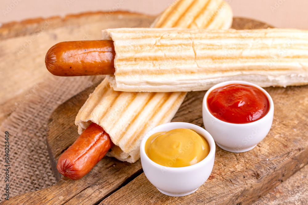 Two tasty grilled french hot dog with mustard and ketchup - obrazy, fototapety, plakaty 