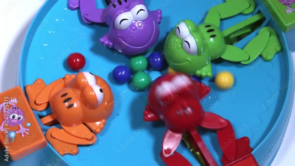Feeding of four hungry plastic frogs with colored balls. Child game on speed of collecting balls. Feeding of four hungry plastic frogs with colored balls. Child game on speed of collecting balls.
