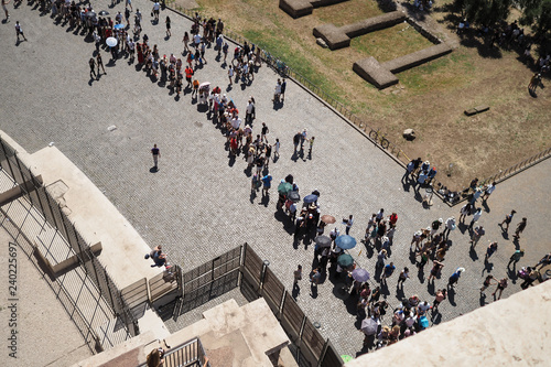Aerial view from the Colosseum of toursists queuing on a hot day in Rome, Italy, holding parasols and umbrellas
