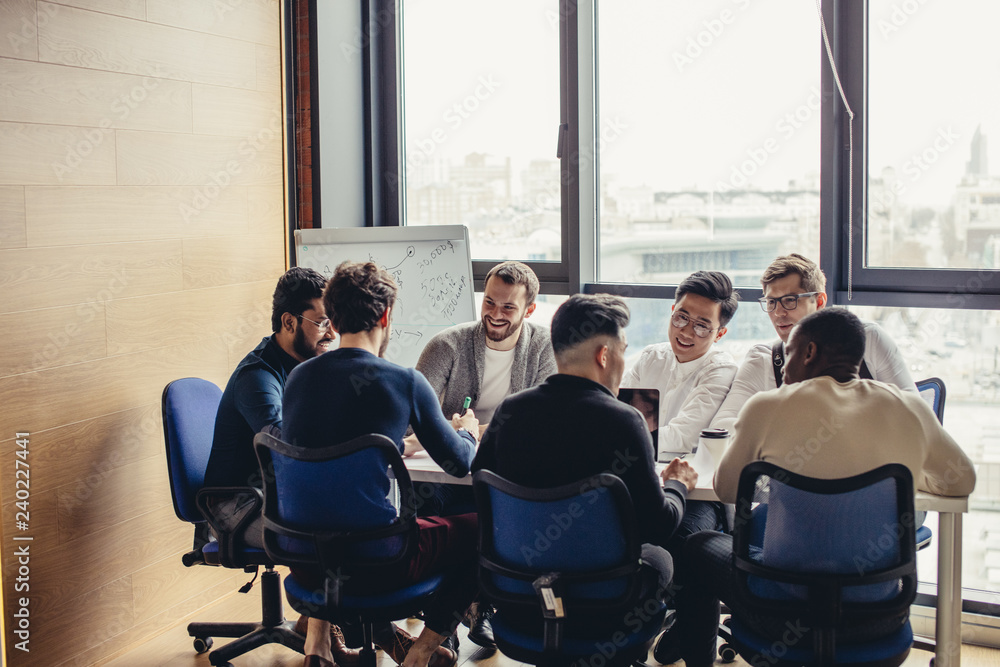 Obraz premium Weekly Meeting of all our sales division multiracial staff in the conference room. Group of business people having discussion in boardroom. Creative business team brainstorming over new project.