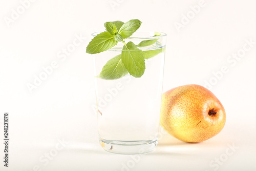 вода чистая в стакане и свежие фрукты на ярком фоне 