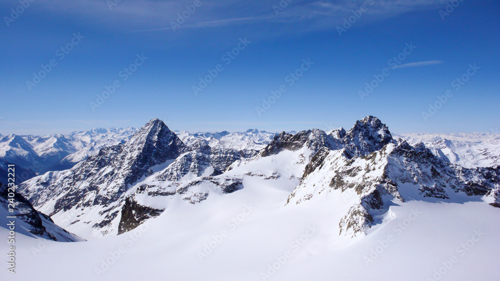 winter mountain landscape in the Swiss Alps with large glaciers and jagged mountain peaks